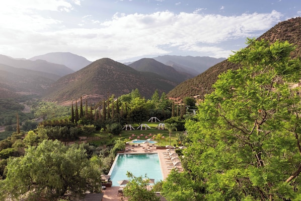 Relax by the serene pool surrounded by lush mountains and tall trees.