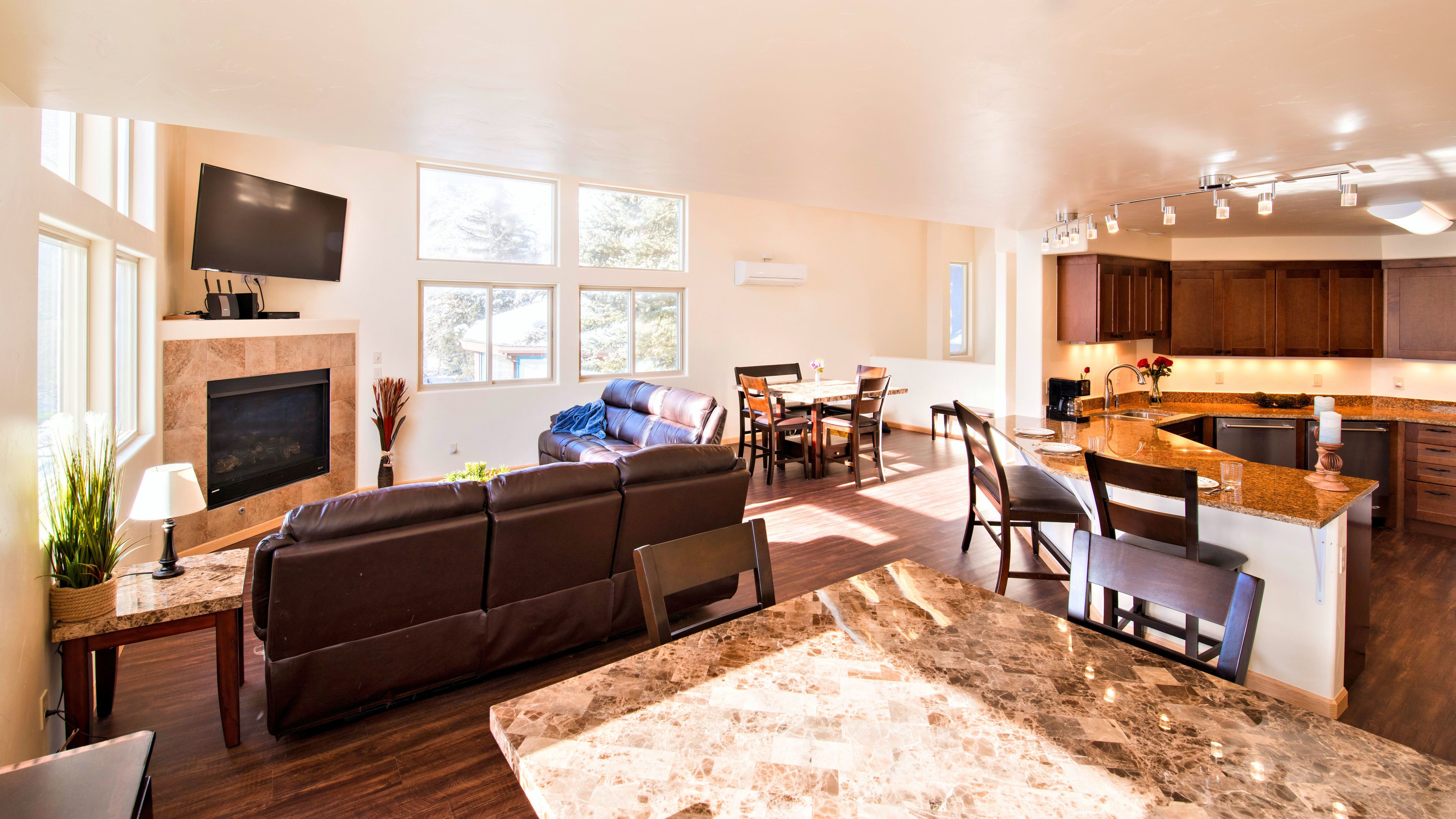 A modern living room with a fireplace, a flat-screen TV, and a large window.