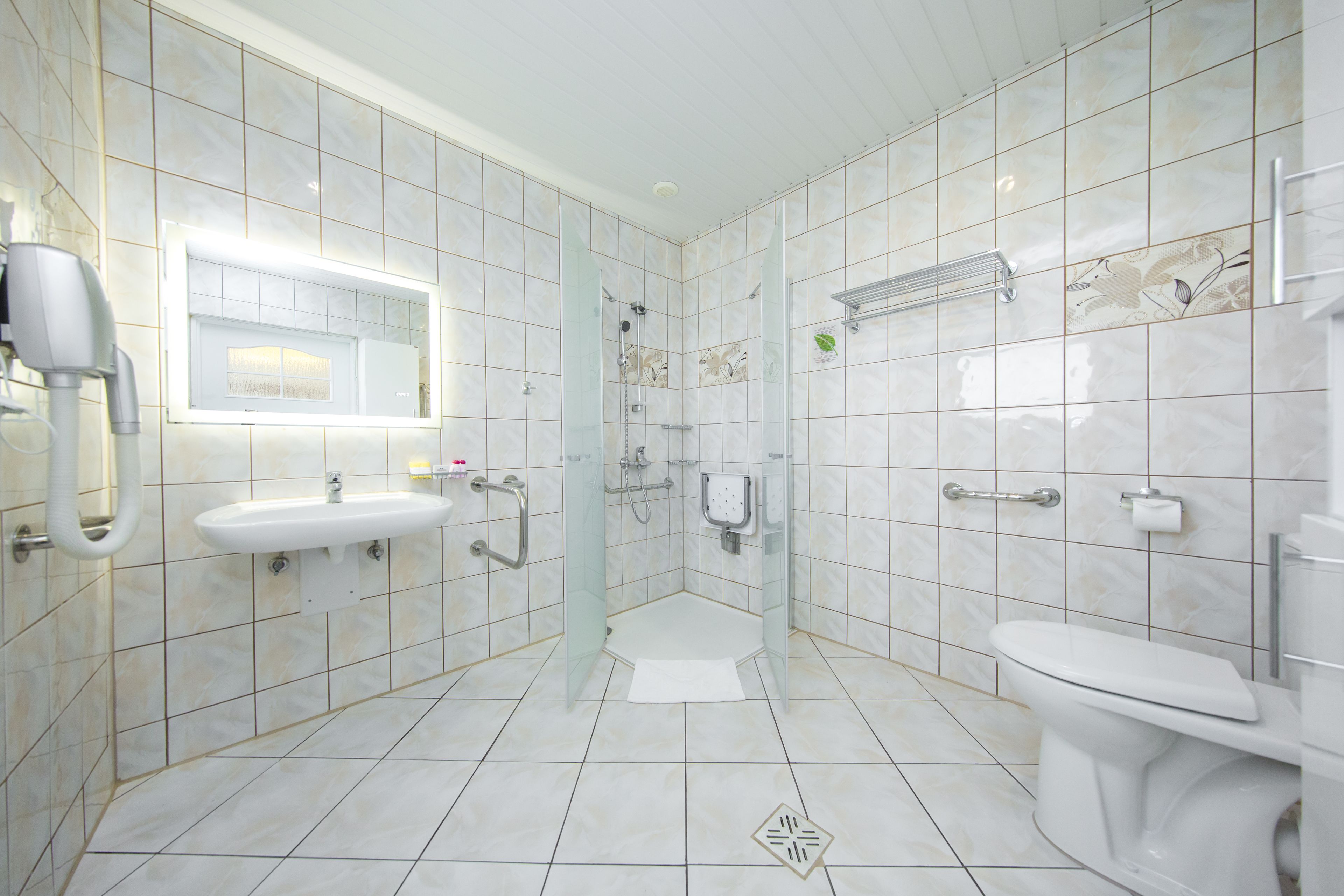 A modern bathroom with a glass-enclosed shower, a sink with a mirror, and a toilet.