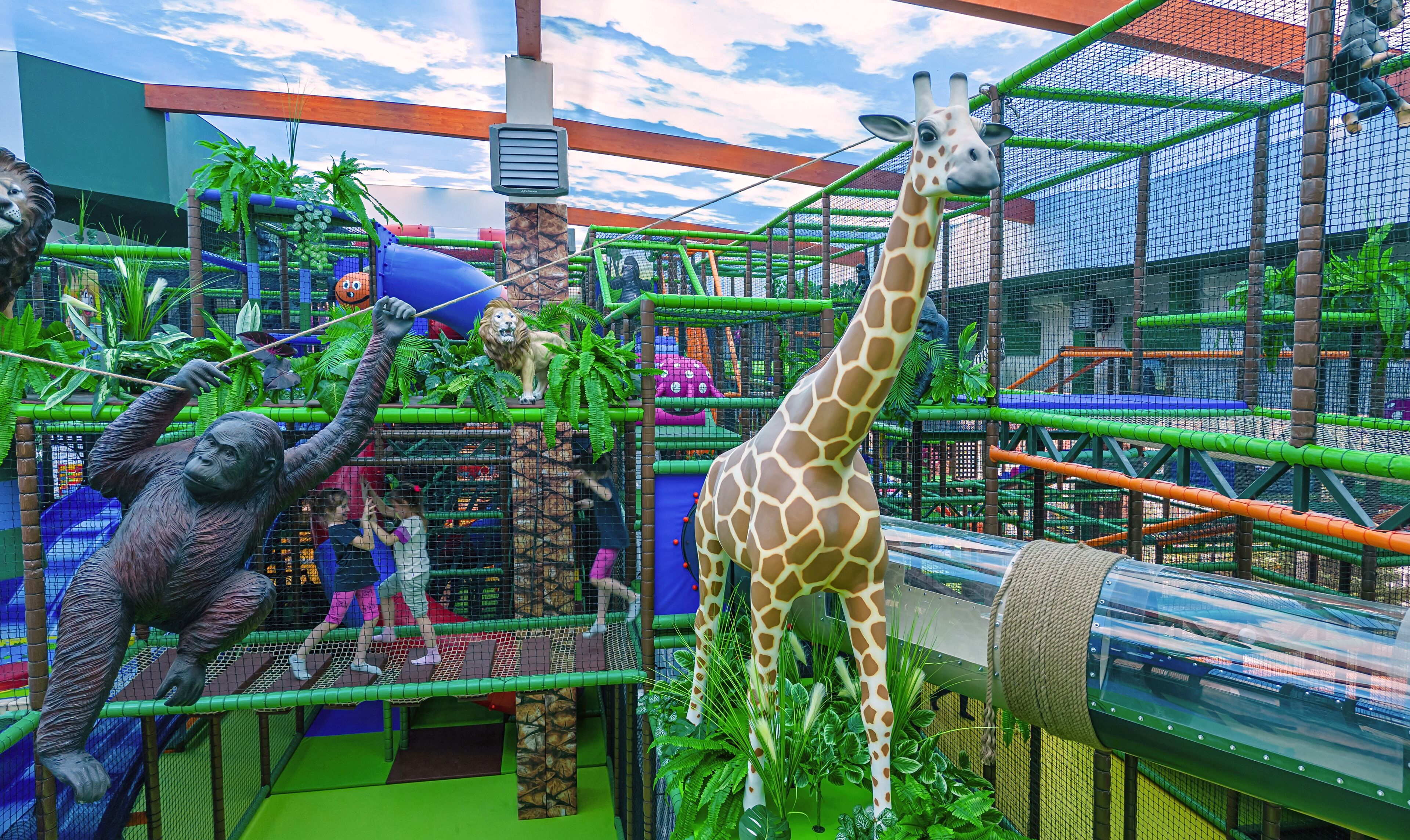 Un enclos de zoo abritant des girafes, un lion et un gorille.