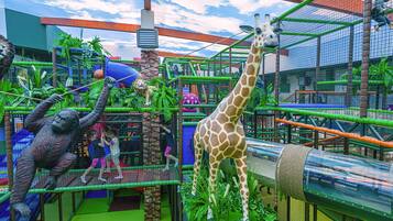 Un enclos de zoo abritant des girafes, un lion et un gorille.