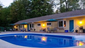 A motel with a swimming pool, outdoor seating, and a covered patio area. - The Pinewood - Adult Getaway by the Lake (Lambton Shores)