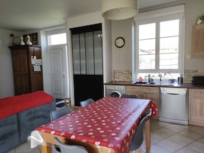 Cocina compacta con lavadora, lavavajillas y ventana con vistas.