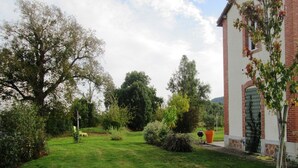A garden with a lawn, a brick building, and various trees. - Holiday Home in Crux-la-Ville near Lake (Crux-La-Ville)