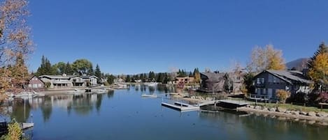 A calm lake with docked boats, surrounded by residential buildings and trees.