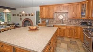 A kitchen with wooden cabinets, a large island, a built-in oven, and pendant lighting. - 2130 Monterey Drive 4 Bedroom Home by RedAwning (South Lake Tahoe)