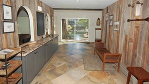 A modern kitchen with a long counter, wooden paneling, and a view to the outdoors. - 2130 Monterey Drive 4 Bedroom Home by RedAwning (South Lake Tahoe)