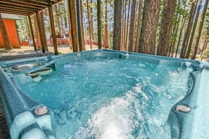 A hot tub in a covered outdoor area surrounded by tall trees. - 2460 Lupine Trail 6 Bedroom Home by RedAwning (South Lake Tahoe)
