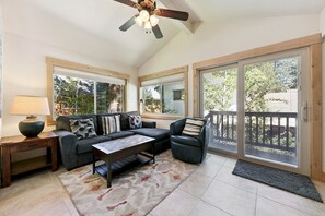A sunlit room with a sofa, armchair, coffee table, and a lamp. - 2806 Springwood Drive 4 Bedroom Home by RedAwning (South Lake Tahoe)