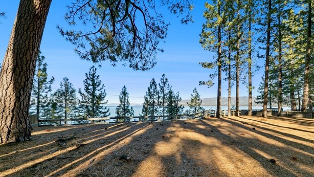 A campground with a clear view of a lake and mountains in the background.