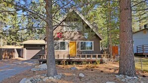 A cabin with a wooden exterior, a front porch, and a garage. - 3542 Bobby Grey Circle 3 Bedroom Cabin by RedAwning (South Lake Tahoe)