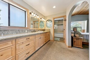 A spacious bathroom with a large window, a walk-in shower, and a vanity with a mirror and lights. - 596 Danube Drive 3 Bedroom Home by RedAwning (South Lake Tahoe)