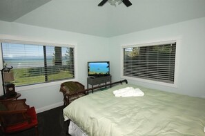 A bedroom with a bed, a television, a chair, and a window with a view of the ocean. - 771 Lakeview Avenue 4 Bedroom Home by RedAwning (South Lake Tahoe)