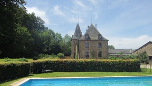 Une piscine avec un bâtiment en pierre en arrière-plan.