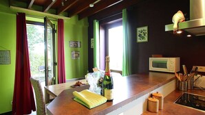Une cuisine avec un plan de travail en bois, une bouteille de champagne et un four à micro-ondes.