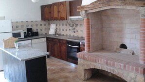 A kitchen with a built-in brick oven, wooden cabinets, a microwave, and a coffee maker. - Historical Charming Vintage Villa with 4 bedrooms & country views 4 Villa by RedAwning (Alcobaça)