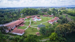 Un resort con varias edificaciones, una piscina y vegetación circundante.
