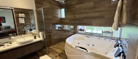 A modern bathroom with a large bathtub, a glass shower enclosure, and a vanity with a mirror.