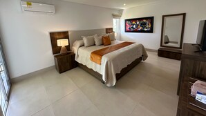 Un dormitorio moderno con una cama grande, mesitas de noche, un televisor y un cuadro en la pared.