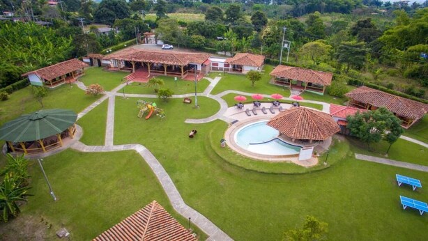 Un resort con piscina, tumbonas y un espacio exterior cubierto.