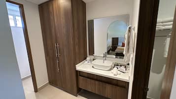 A modern bathroom with a large wooden cabinet, a white sink, and a mirror above it.