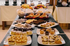 Una mesa de bufé con diversos postres y pasteles.