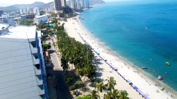 A coastal cityscape with a beach, high-rise buildings, and a clear blue sea. - Apartamento Tropical - Smr245a (Santa Marta)