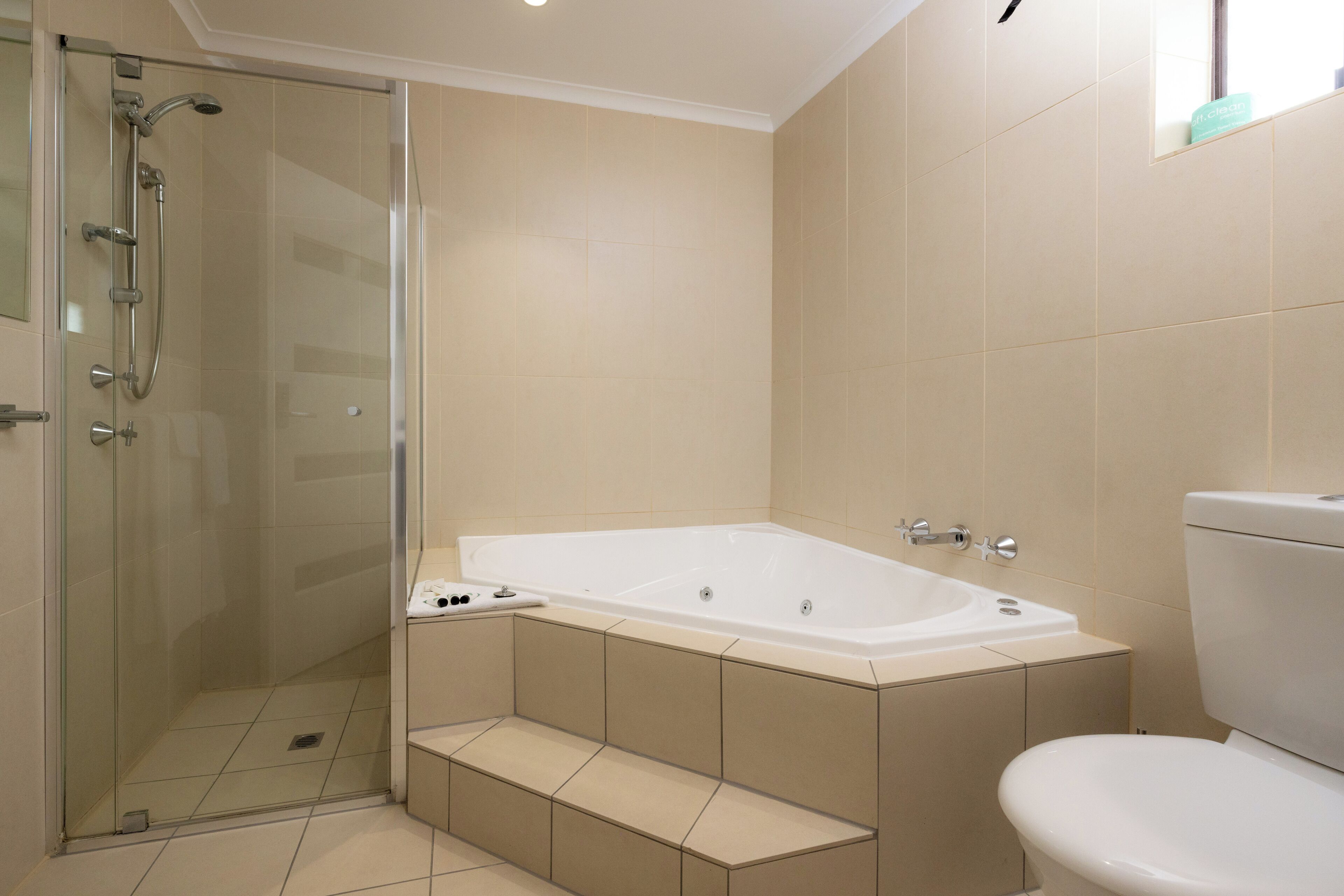 A bathroom with a glass-enclosed shower, a freestanding bathtub, and a toilet.