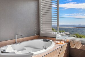A modern bathroom with a freestanding bathtub, a view of the mountains through a large window, and a wooden countertop. - Altitude on Montville (Montville)