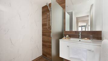 Une salle de bain moderne avec une douche à l’italienne en verre, un meuble-lavabo en bois et un grand miroir.