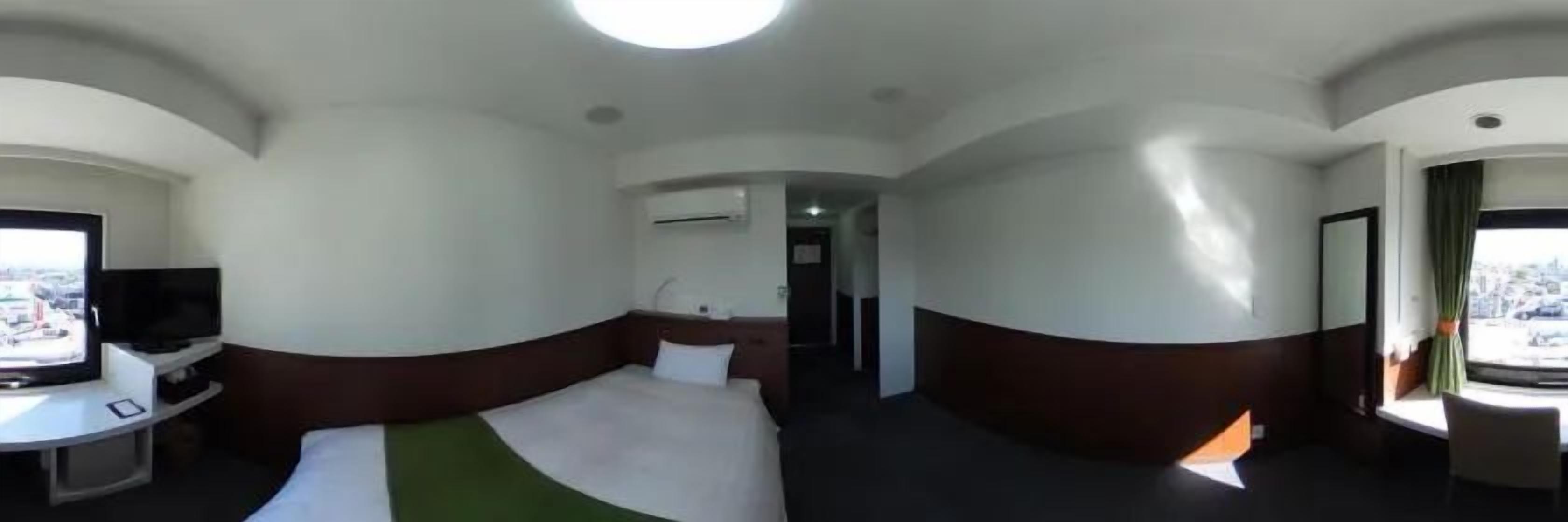 Une chambre d’hôtel avec un lit, un bureau, une télévision et une fenêtre donnant sur un paysage agréable.