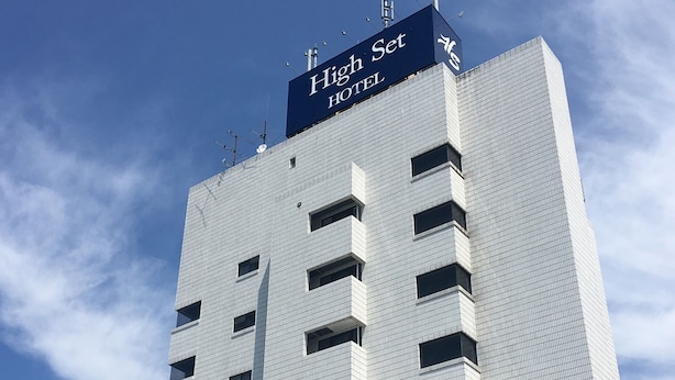 Un edificio de hotel alto con un letrero que dice 'High Set HOTEL' en la parte superior.