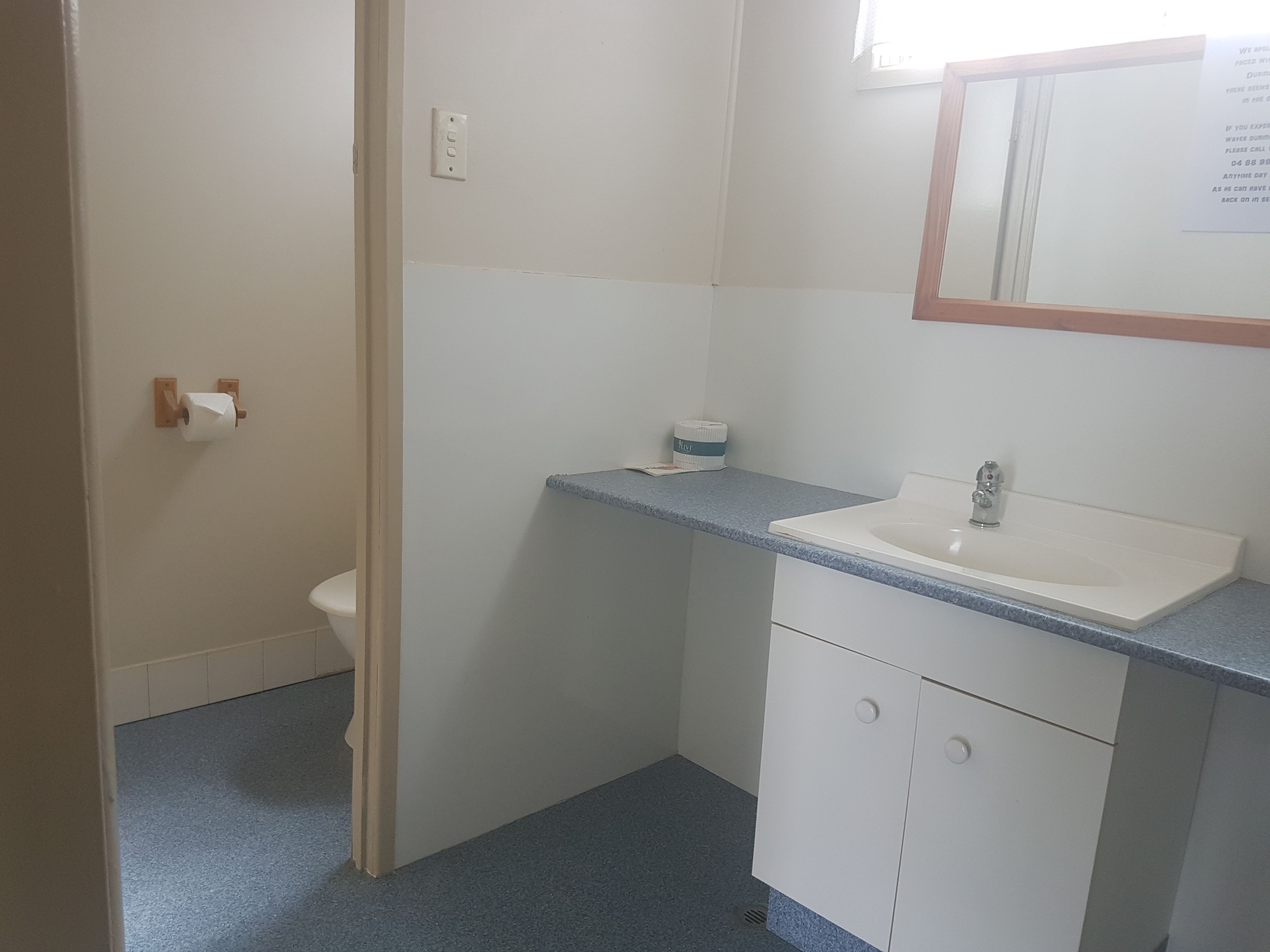 Ein kleines Badezimmer mit Toilette, Waschbecken und Spiegel.
