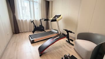 A home gym with a treadmill, stationary bike, and elliptical machine.