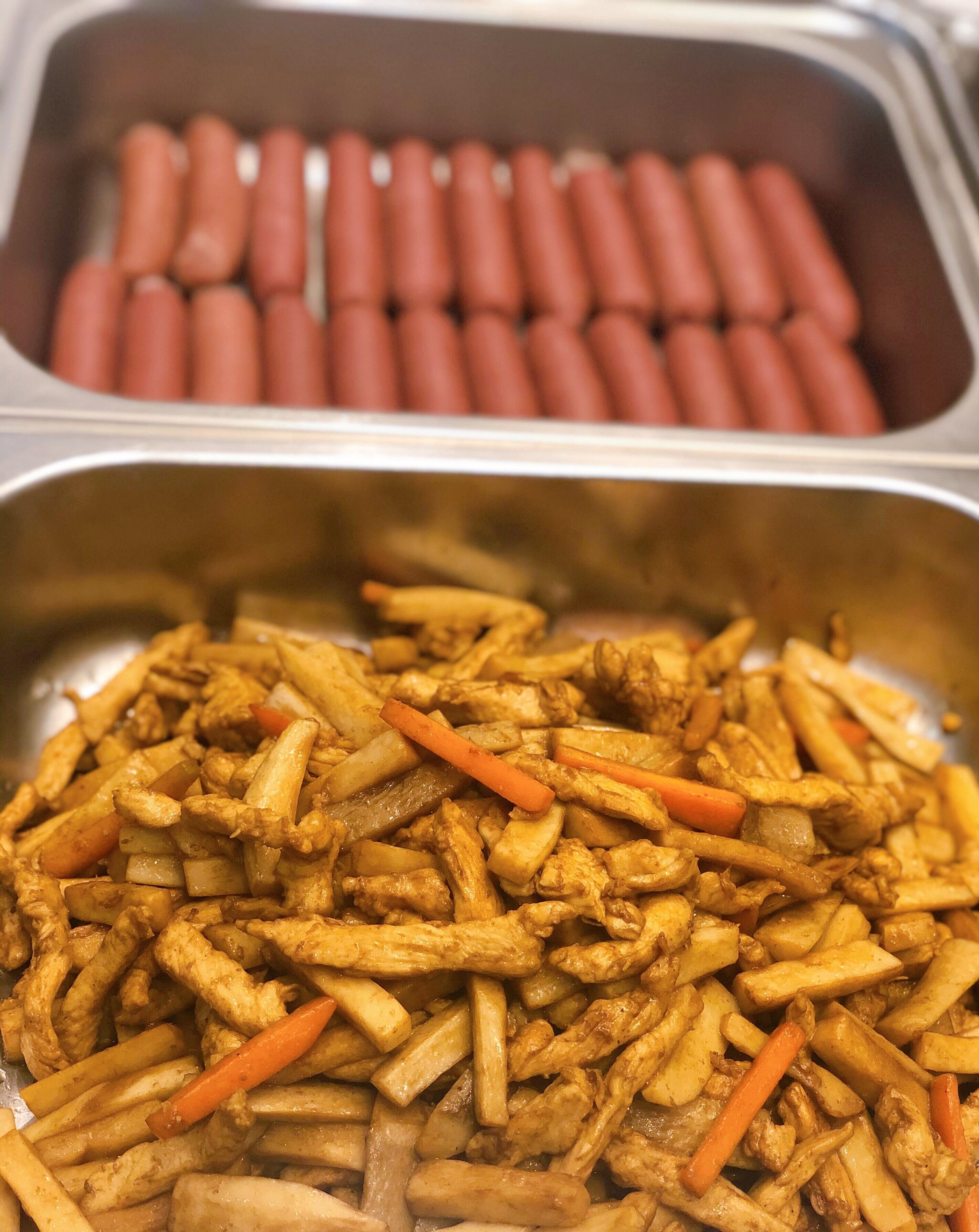 A buffet with French fries and hot dogs.