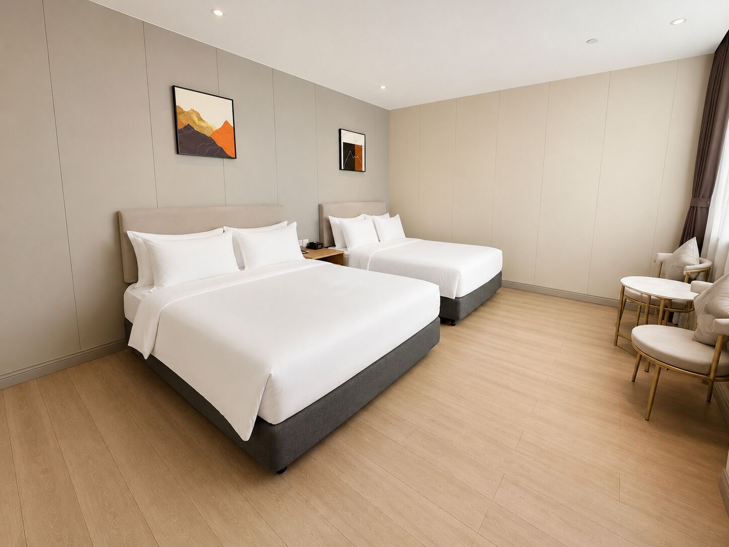 A hotel room with two beds, a small table, and a chair.