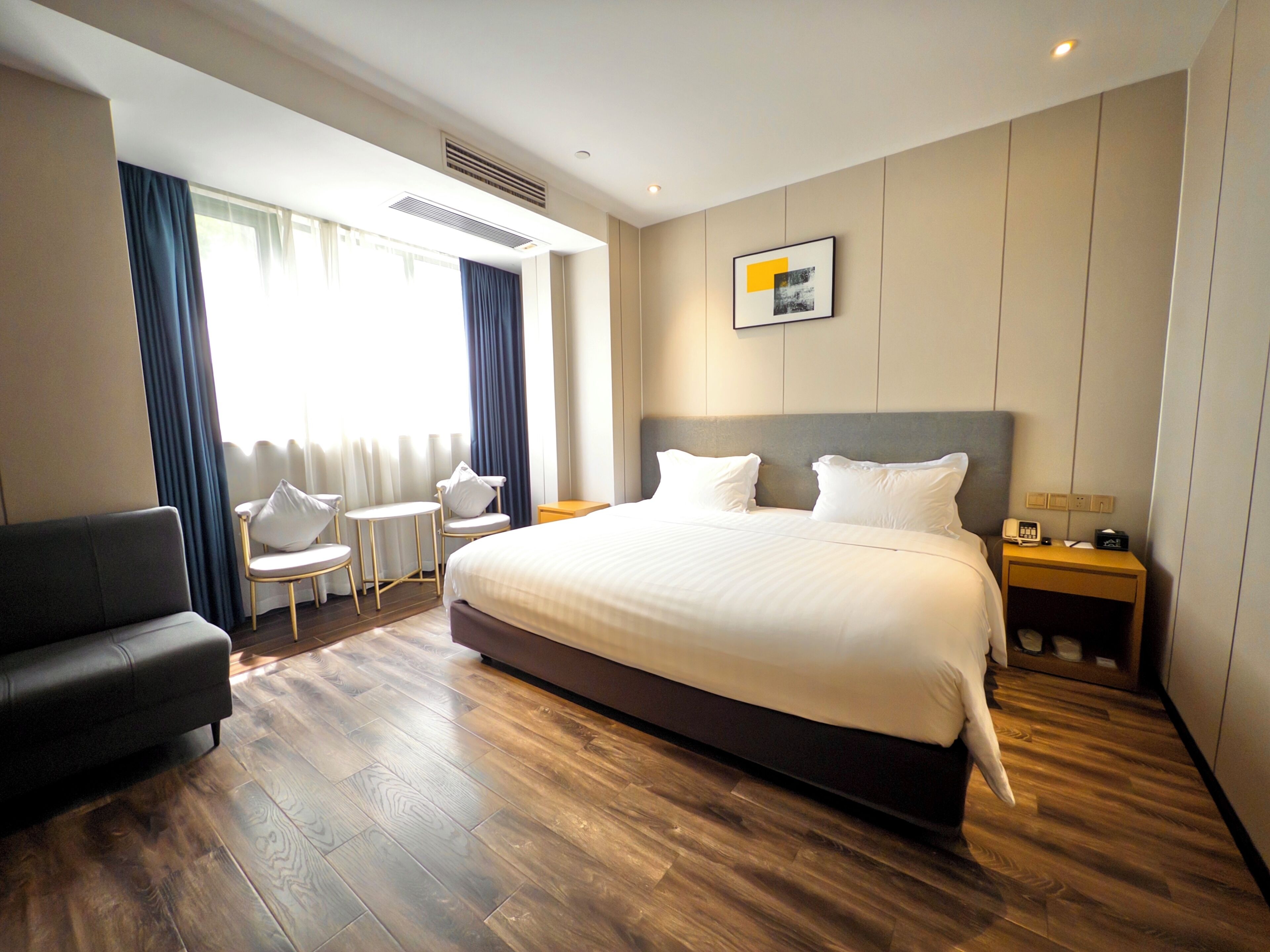 Een hotelkamer met een groot bed, een bank, een kleine tafel en een stoel.