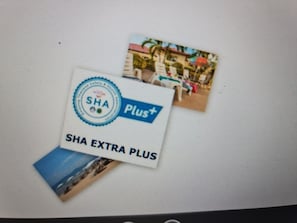 A promotional card for SHA EXTRA PLUS, featuring a circular logo and a plus sign.