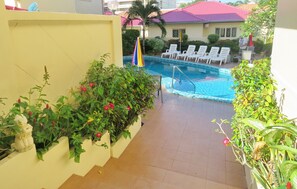 A pool area with lounge chairs and a flagpole.