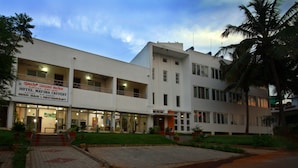 Un edificio de dos pisos con un letrero que dice 'Mayura Cauvery Beer Bar & Restaurant'.