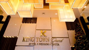 The King Town Grand Hotel & Wedding Center sign with a modern geometric light fixture above. - King Town Grand Hotel & Wedding Center (Bac Nha Trang)