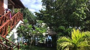 A garden with a wooden staircase, various plants, and a thatched structure. - Beach Villa Lanka (Tangalle)