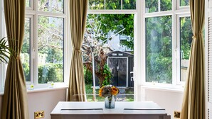 Une pièce avec une table et une fenêtre avec des rideaux.