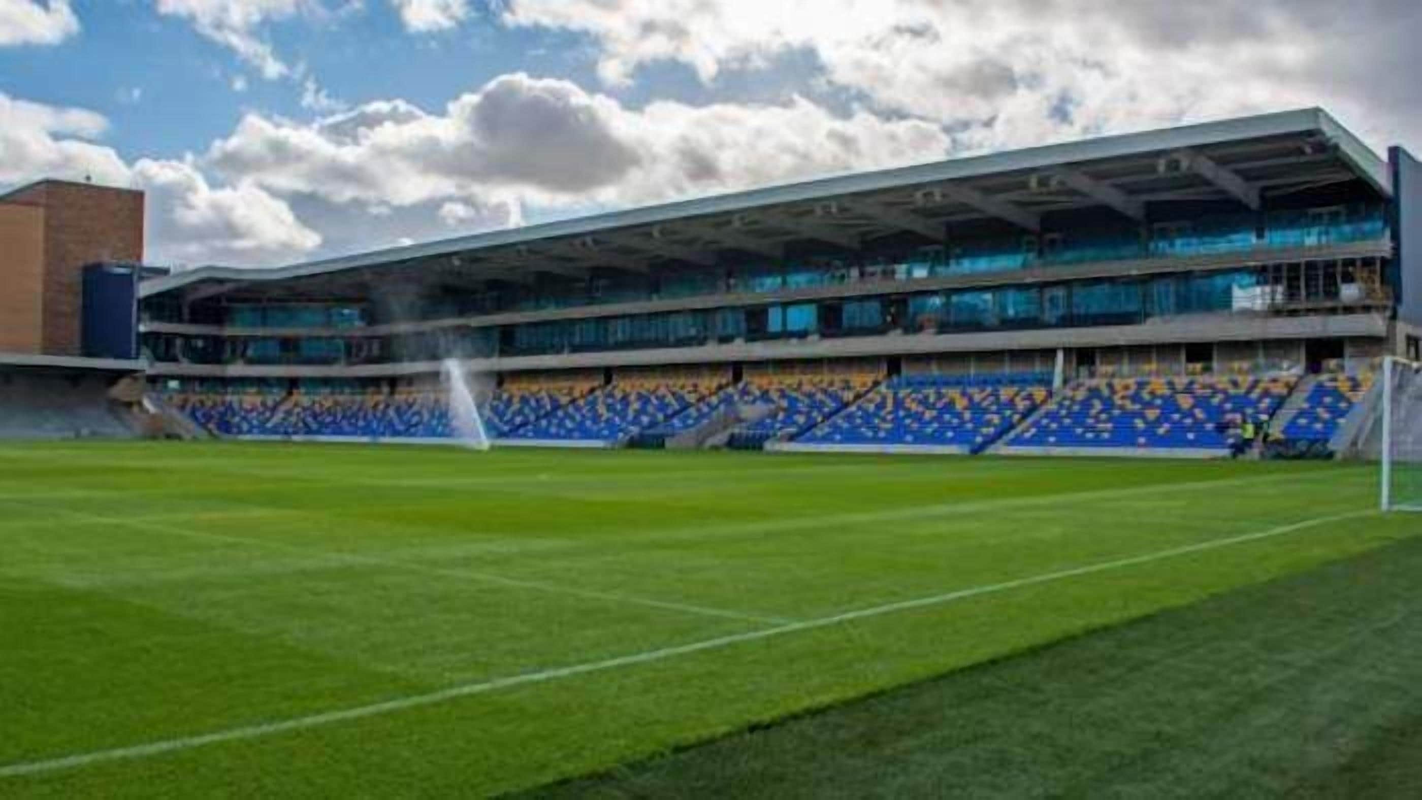 A stadium with tiered seating and a goalpost.