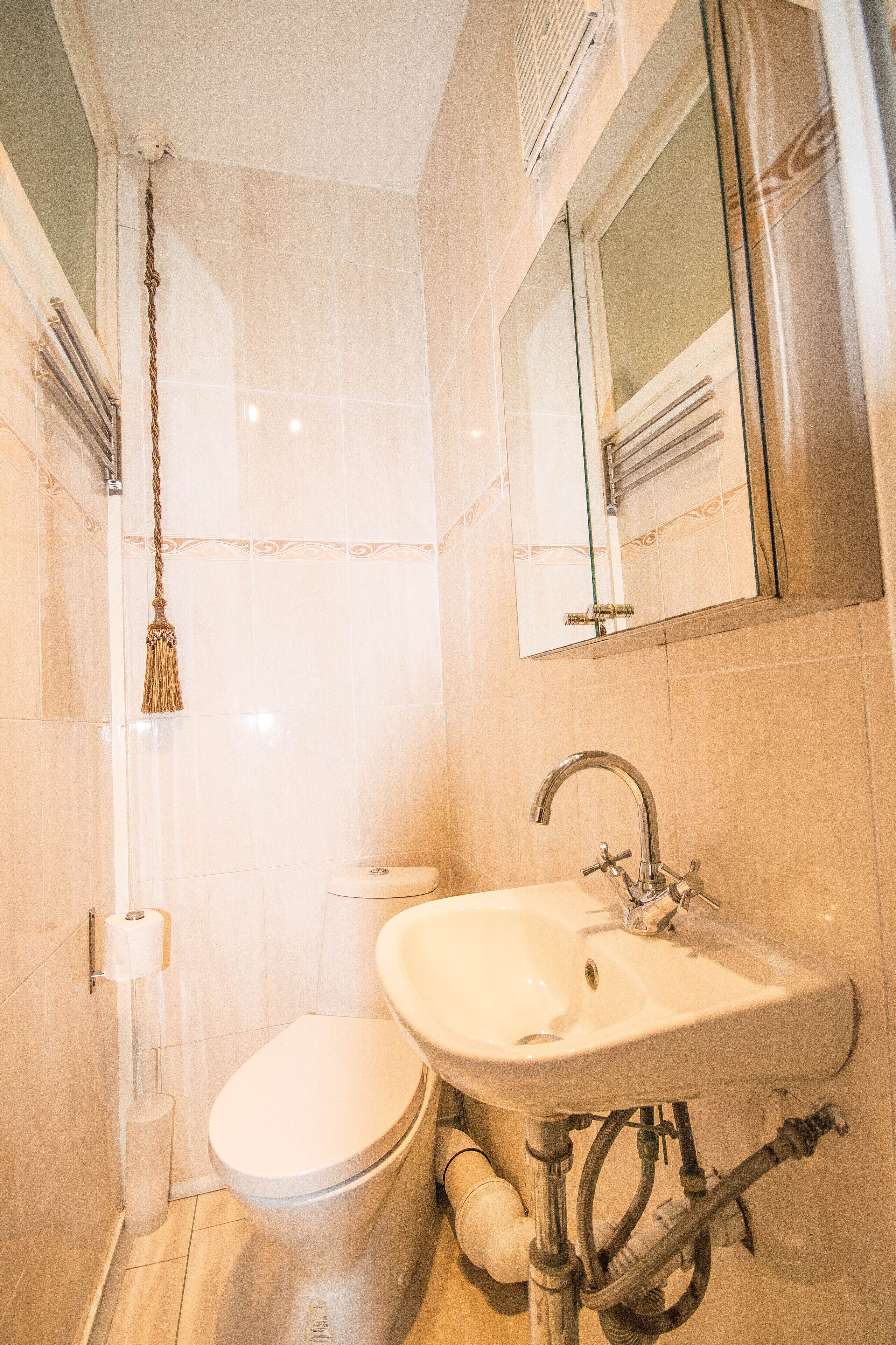A bathroom with a toilet, sink, and mirror.