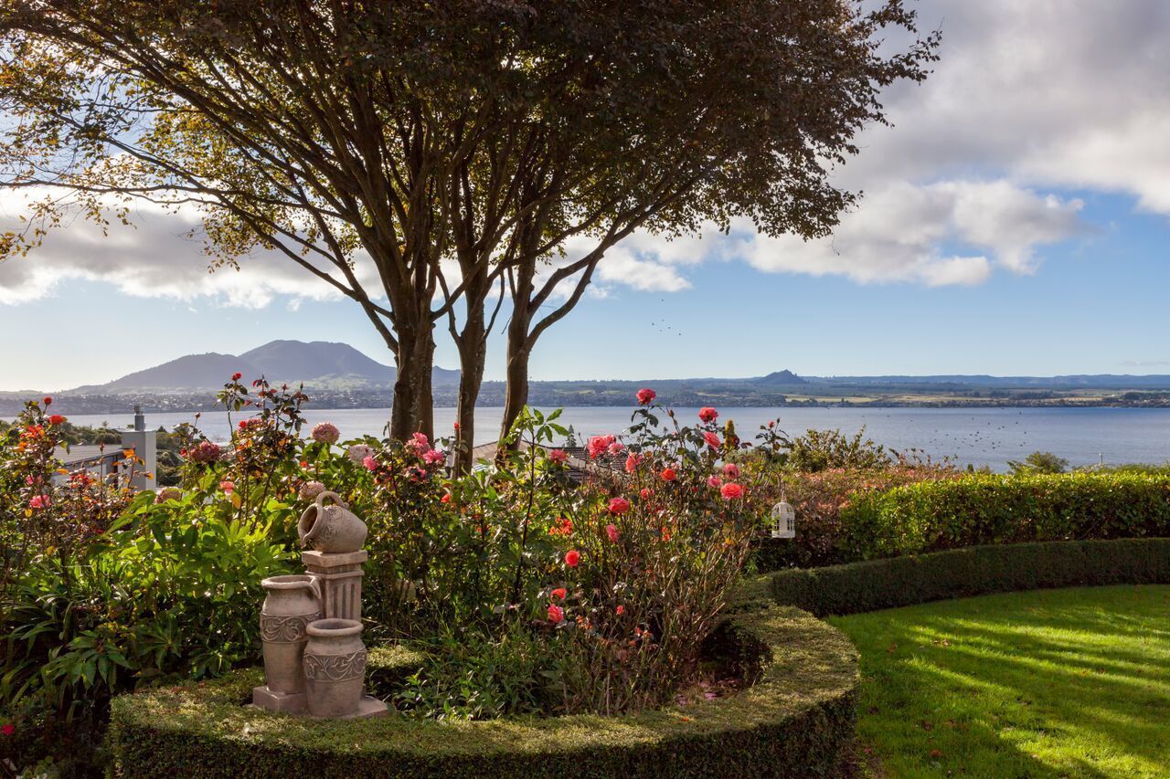 Un jardin aménagé offrant une vue sur un lac et des montagnes.