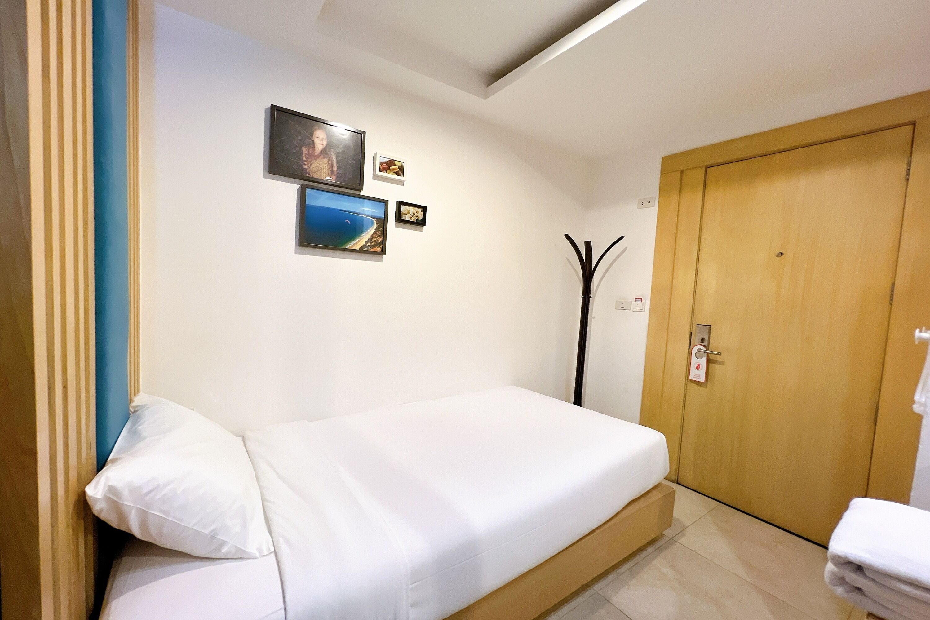 Une chambre à coucher avec un lit, une porte en bois et des tableaux accrochés au mur.