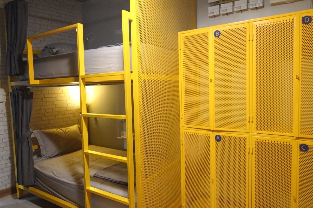 A bunk bed with a ladder, a metal storage unit, and a set of lockers.