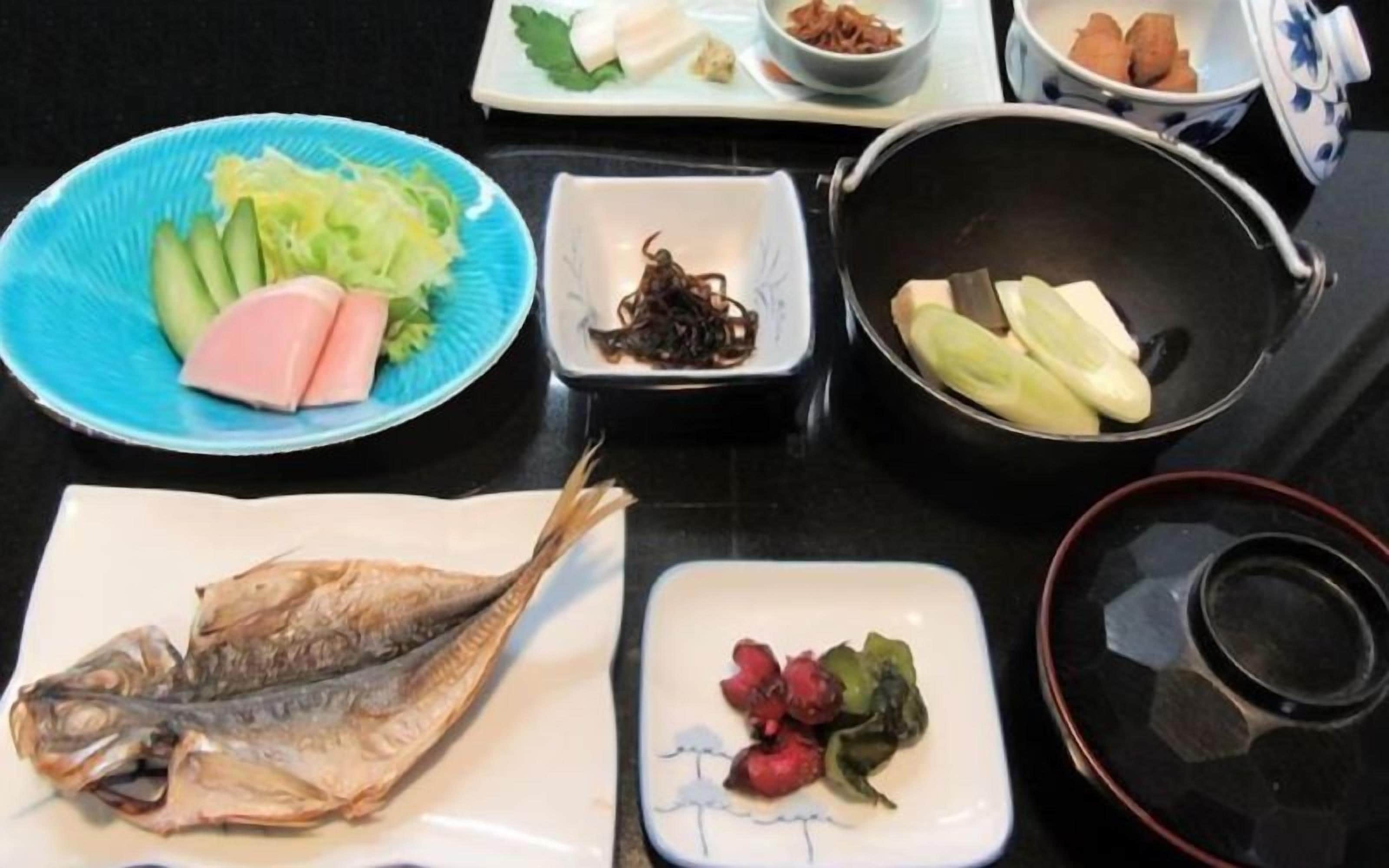 A table with various food items including fish, vegetables, and condiments.
