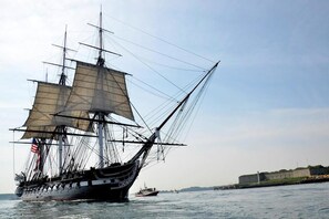 A large sailing ship with multiple masts and sails, docked near a fortified structure. - Shimoda Ocean Park Hotel (Shimoda)